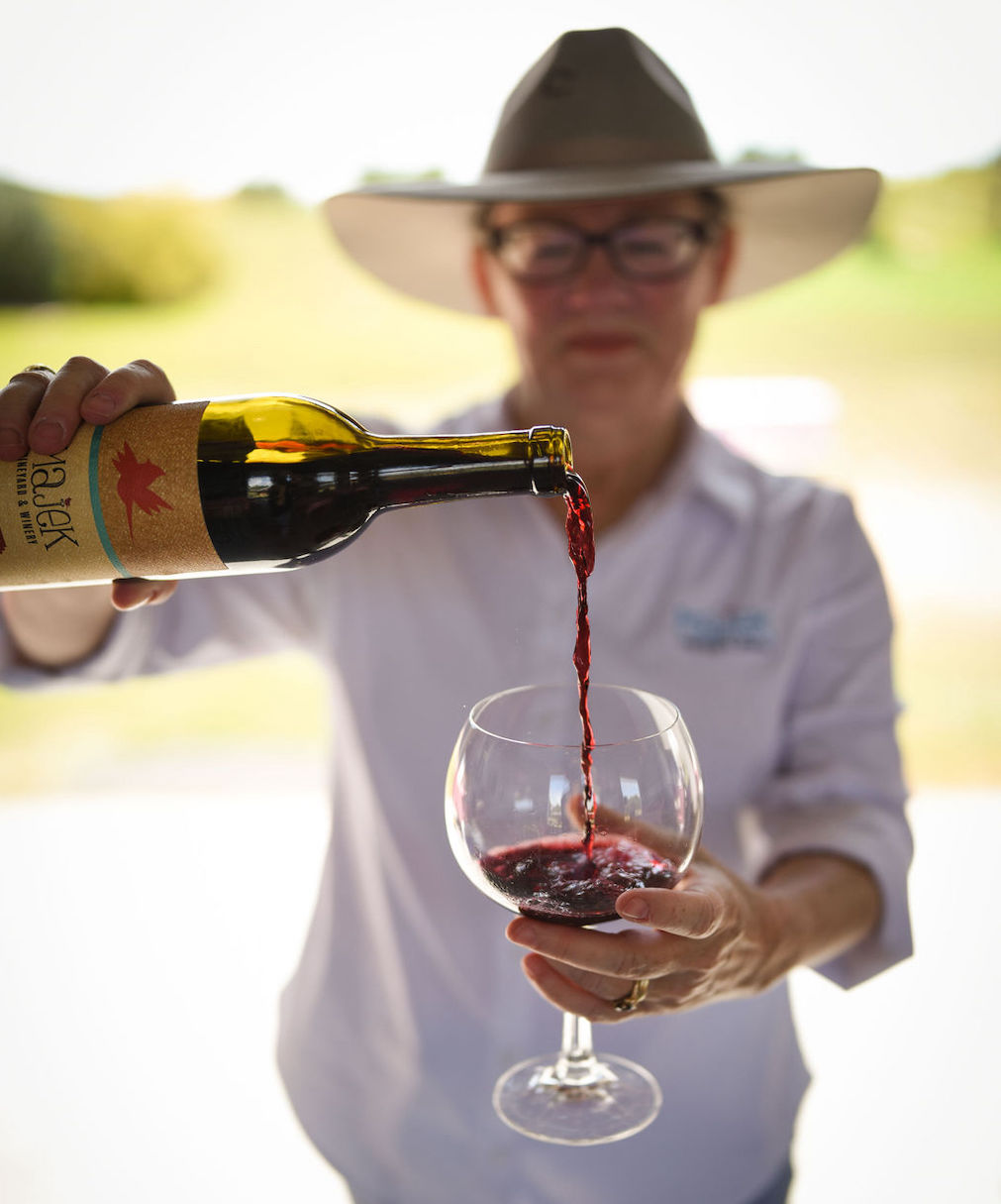 Lynne Majek pouring a glass of Majek Vineyards wine