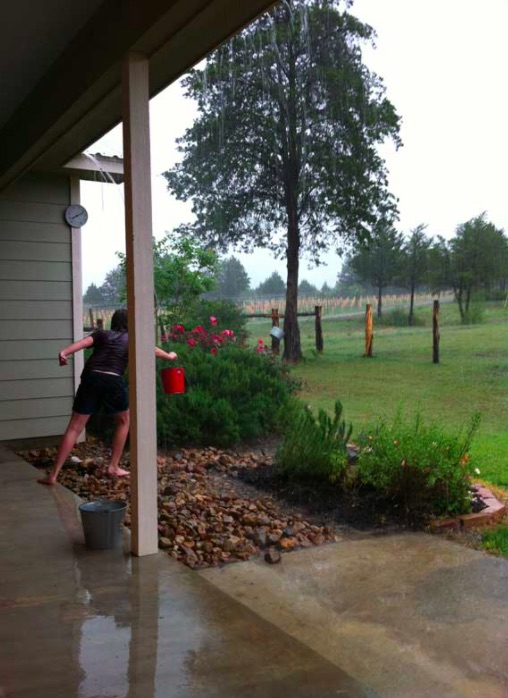 Person reaching for a bucket on a rainy day